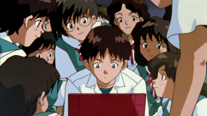 A crowd of schoolgirls circle around Shinji Ikari's desk while he reads from his laptop