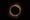 An image of a solar eclipse: a round black moon over a yellow sun, on a black background